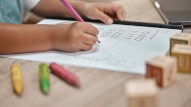 Education, paper and hands of child writing numbers