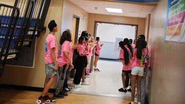 WEB program leaders line up to welcome new students through the gym doors.