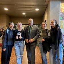 Female students pose with superintendent